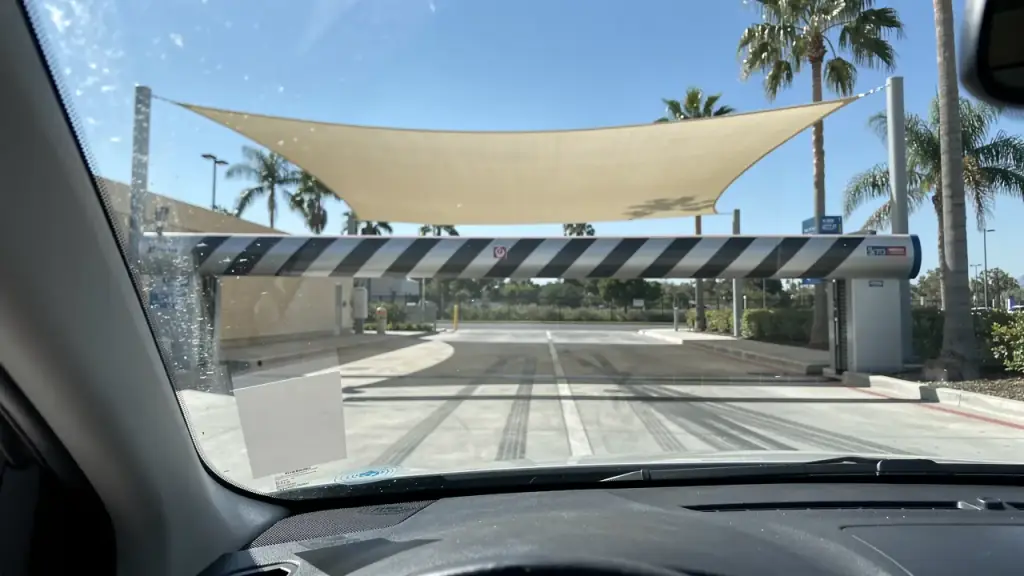 Blank RFID tag on the lower left of a windshield as the striped entry gate lifts